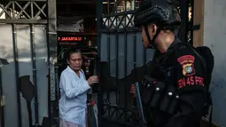 Peristiwa itu menimbulkan kepanikan di kalangan siswa dan guru yang sedang bersiap menjalankan ibadah salat Jumat. Tampak dalam foto, seorang wanita keluar dari gerbang SMAN 72 Jakarta di Jakarta pada Jumat 7 November 2025. (YASUYOSHI CHIBA/AFP)