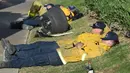 Sejumlah petugas pemadam kebakaran (damkar) beristirahat setelah berusaha menjinakkan kebakaran liar yang disebut Lilac Fire di Bonsall, California, Jumat (8/12). Para petugas damkar itu kewalahan setelah berjuang lebih dari 20 jam. (Robyn Beck/AFP)
