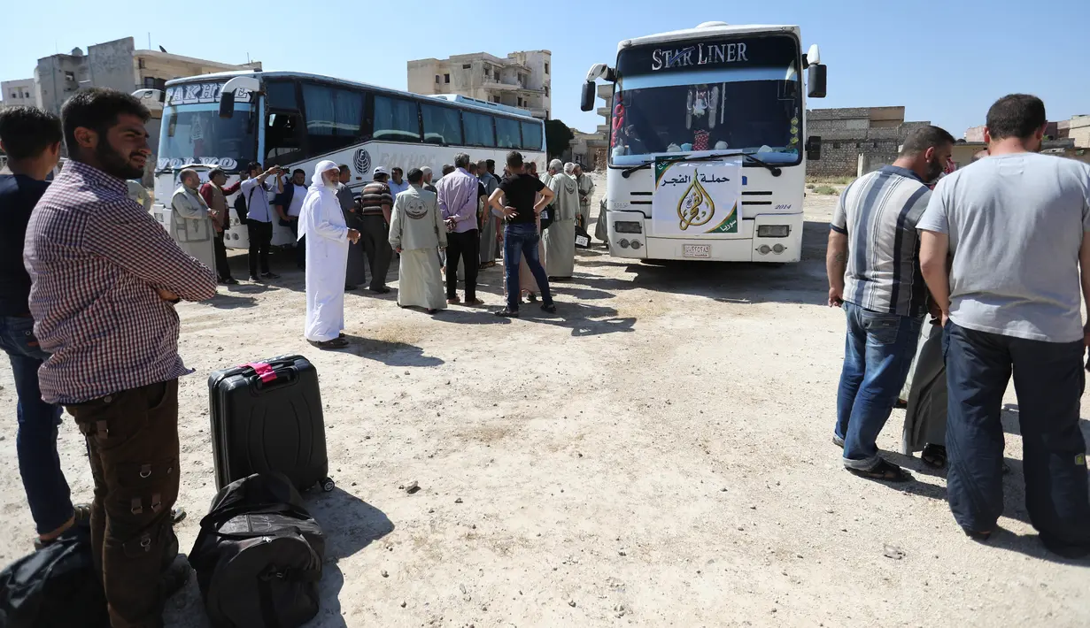 Warga Suriah dari provinsi Idlib, berkumpul sebelum menaiki bus ke Tanah Suci Makkah di kota Binnish, Senin (22/7/2019). Jemaah calon haji asal Suriah melakukan perjalanan ke Arab Saudi untuk menjalankan ibadah haji dari perbatasan Bab al-Hawa yang berseberangan dengan Turki. (Omar HAJ KADOUR/AFP)