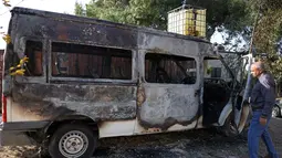 Situasi ini memicu kecaman internasional serta kritik dari internal militer dan pemerintah Israel sendiri. Tampak dalam foto, seorang pria Palestina memeriksa kendaraan yang rusak akibat serangan oleh pemukim Israel di desa Jabaa dekat Bethlehem, di Tepi Barat yang diduduki, pada Selasa 18 November 2025. (AHMAD GHARABLI/AFP)
