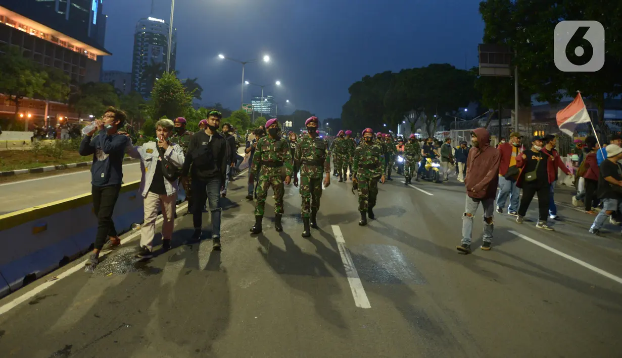 Anggota Marinir mengawal pulang pendemo saat aksi menolak Omnibus Law UU Cipta Kerja di kawasan Patung Kuda, Jakarta, Selasa (20/10/2020).  Anggota Marinir membubarkan dan mengawal pulang massa pendemo  ke rumah masing-masing. (merdeka.com/Imam Buhori)
