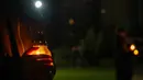 Orang-orang membawa lilin di tugu peringatan yang didedikasikan untuk petugas pemadam kebakaran dan pekerja yang meninggal setelah bencana nuklir Chernobyl, menjelang peringatan 40 tahunnya di Slavutych, Ukraina, Sabtu, 25 April 2026. (AP Photo/Dan Bashakov)