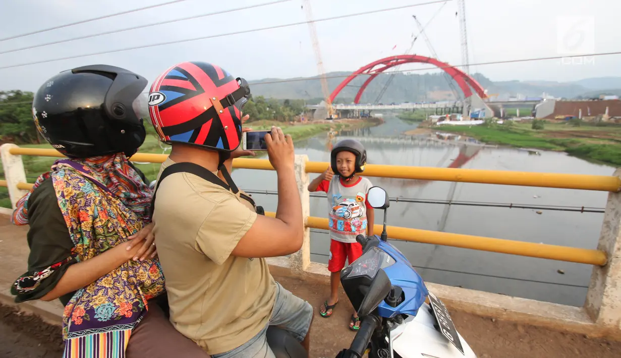 Seorang anak berpose dengan latar Jembatan Kali Kuto di ruas tol fungsional Batang-Semarang, Gringsing, Jateng, Rabu (13/6). Berfungsinya Jembatan ini akan memperlancar arus mudik dan arus balik Lebaran 2018. (Liputan6.com/Arya Manggala)