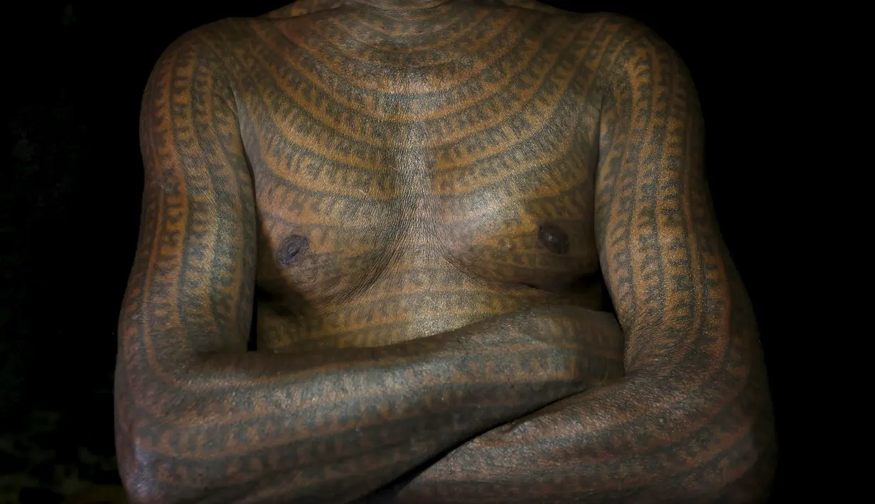 Seorang pengikut Ramnami Samaj menato sekujur tubuhnya di desa Jamgahan, India, 17 November 2015. Simbol tato yang mereka yaitu nama dewa Ram Hindu. (REUTERS / Adnan Abidi)