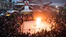 Orang-orang menonton patung Lady Winter yang dibakar saat perayaan Shrovetide di Moskow, Rusia (18/2). Shrovetide atau Maslenitsa adalah hari raya keagamaan dari Slavia Timur. (AP Photo / Pavel Golovkin)