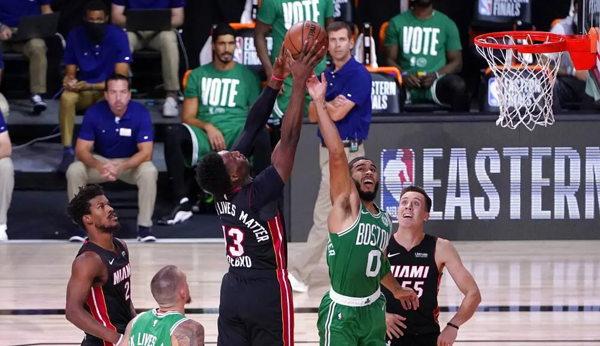 Pebasket Boston Celtics, Jayson Tatum, berebut bola dengan pebasket Miami Heat, Bam Adebayo, pada gim keempat final NBA Wilayah Timur di AdventHealth Arena, Kamis (24/9/2020). Miami Heat menang dengan skor 109-112. (AP/Mark J. Terrill)
