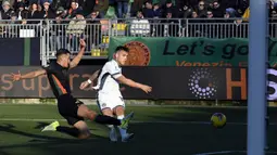 Pemain Venezia, Jay Idzes (kiri) berusaha menghalau tendangan pemain Inter Milan, Lautaro Martinez pada laga lanjutan Liga Italia 2024/2025 di Pier Luigi Penzo Stadium, Venice, Minggu (12/01/2025) malam WIB. (AFP/Andrea Pattaro)