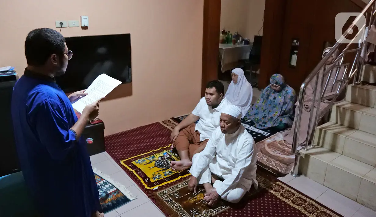 Warga mendengarkan khotbah saat melaksanakan salat Idul Fitri di kediamannya kawasan Mekarsari, Depok, Jawa Barat, Minggu (24/5/2020). Warga menjalankan salat Idul Fitri di rumah saat pandemi COVID-19. (Liputan6.com/Herman Zakharia)