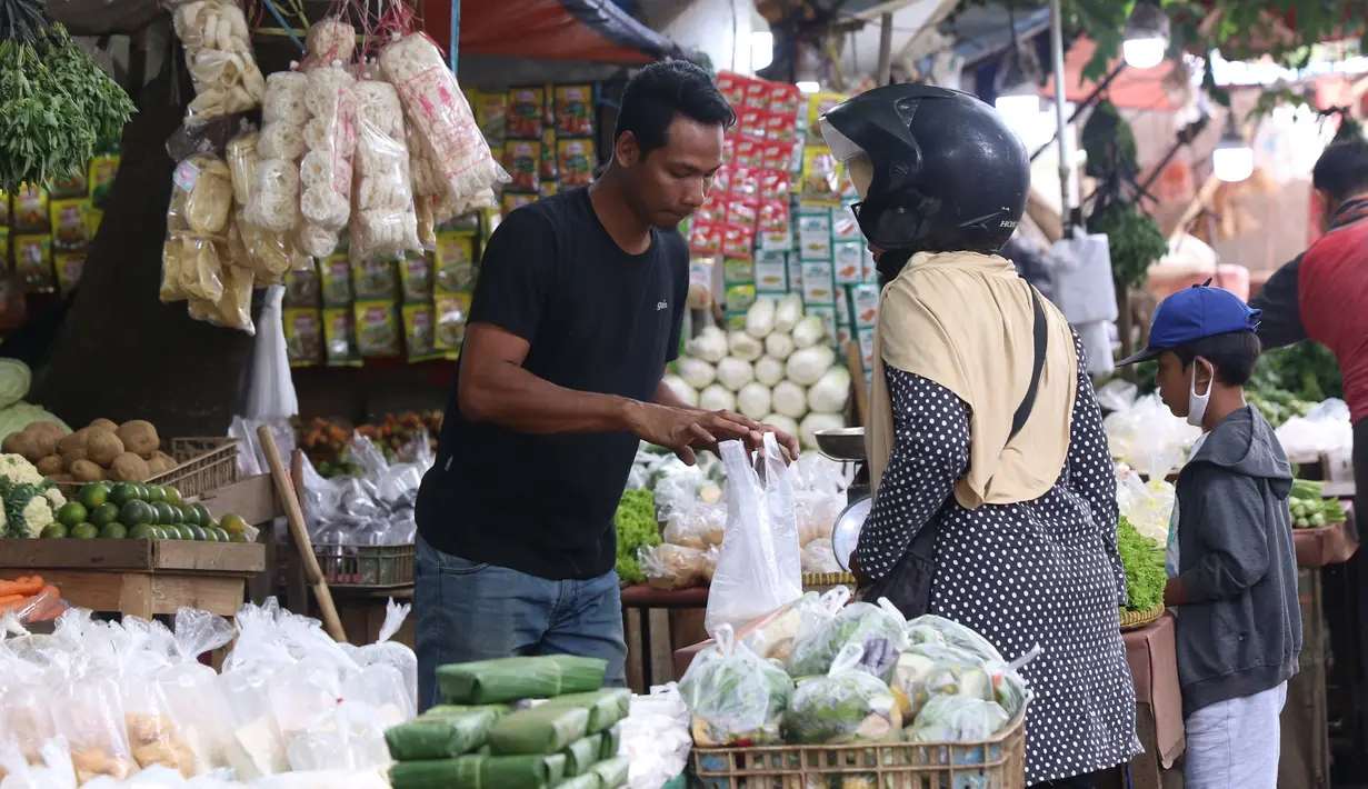 Pedagang melayani pembeli di pasar kawasan Tangerang, Senin (7/2/2022). Ekonom Centre for Strategic and International Studies (CSIS) meminta pemerintah bisa mengantisipasi ketersediaan bahan pokok seiring peningkatan kasus COVID-19 varian Omicron. (Liputan6.com/Angga Yuniar)