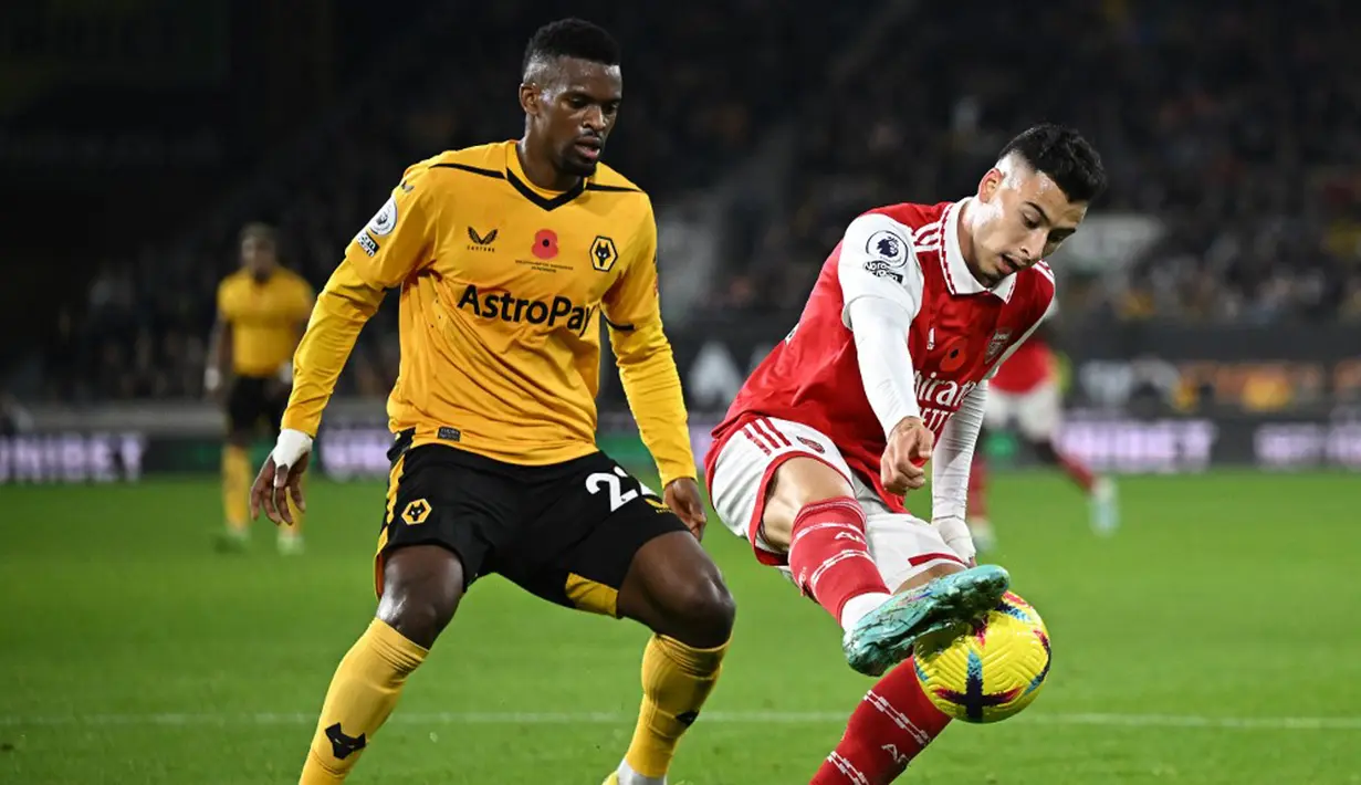 Pemain Wolverhampton Wanderers Nelson Semedo (kiri) berebut bola dengan pemain Arsenal Gabriel Martinelli (kanan) pada pertandingan sepak bola Liga Inggris di Stadion Molineux, Wolverhampton, Inggris, 12 November 2022. Arsenal menang 2-0. (Oli SCARFF/AFP)
