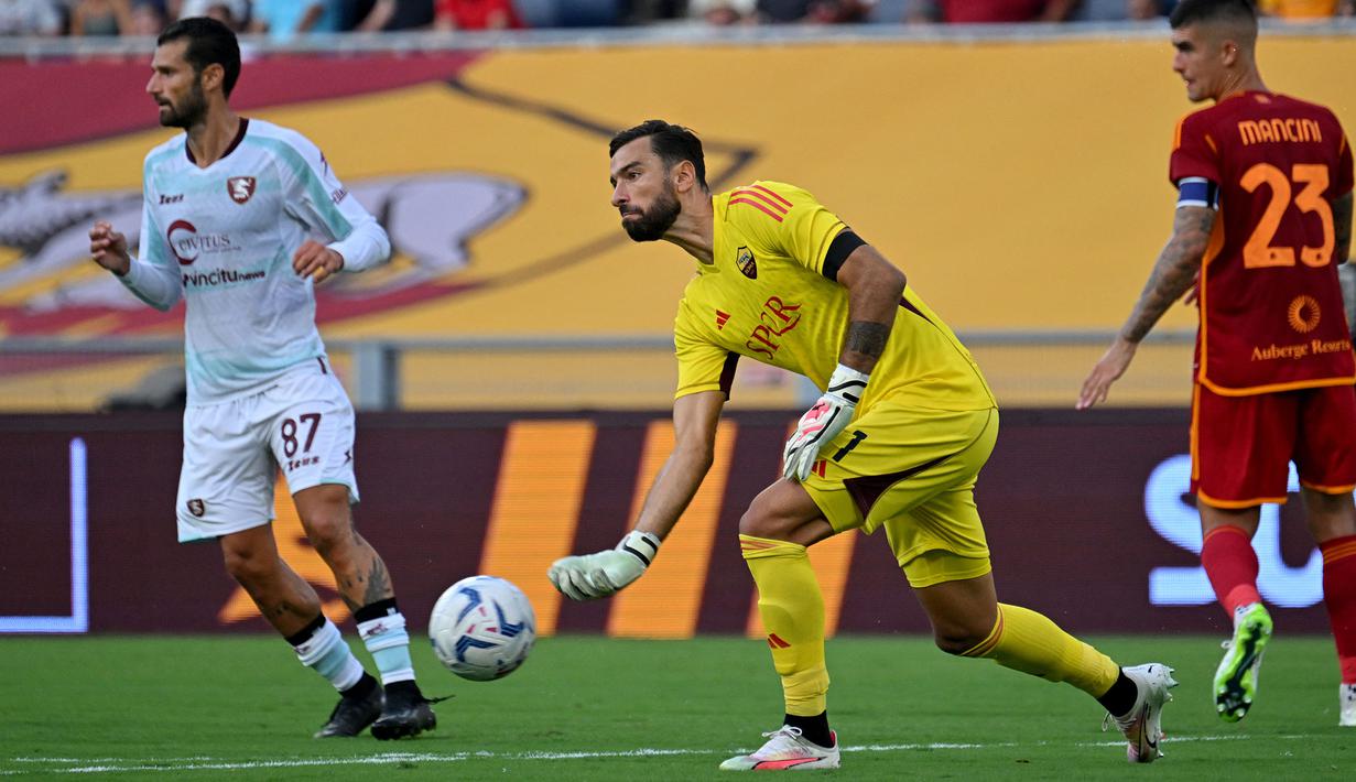Kiper asal Portugal berusia 36 tahun, Rui Patricio yang didatangkan AS Roma sejak awal musim 2021/2022 dari Wolverhampton Wanderers mampu membawa Il Giallorossi menempati posisi kelima klasemen sementara Serie A 2023/2024 dengan mengoleksi 51 poin setelah melewati 29 laga. Tampil dalam 23 laga, ia sukses membuat 6 kali clean sheet dan kebobolan 27 gol. Namun posisinya kini mulai terancam setelah dalam lima laga terakhir ia harus duduk di bangku cadangan digantikan kiper asal Serbia, Mile Svilar. (AFP/Alberto Pizzoli)