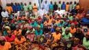Presiden Nigeria Muhammadu Buhari (tengah) duduk di antara 82 gadis Chibok yang berhasil dibebaskan dari Boko Haram di Presidential Villa di Abuja, Nigeria (7/5). (AFP Photo/PGDBA&HND Mass Communication)