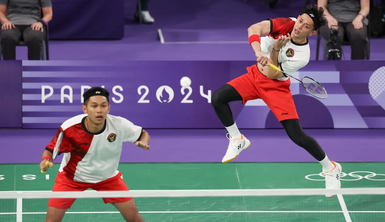 <p>Pemain ganda putra Indonesia, Muhammad Rian Ardianto (kanan) melepaskan smes saat menghadapi wakil Prancis, Lucas Corvee/Ronan Labar pada laga Grup C Olimpiade Paris 2024 di Porte De La Chapelle Arena, Paris, Senin (29/7/2024). Fajar Alfian/Muhammad Rian Ardianto menang dua gim langsung 21-13, 21-10. (Dok. NOC Indonesia/Naif Muhammad Al'as)</p>