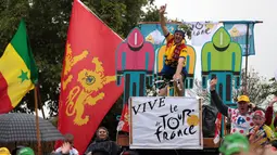 Seorang penonton bergaya ala pebalap saat menyambut kehadiran para peserta di Etape 2 Tour de France antara Saint-Lo dan Cherbourg-en-Cotentin, (3/7/2016). (AFP/Kenzo Tribouillard)