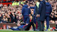 Pelatih MU, Louis van Gaal, memprotes wasit cadangan dengan menjatuhkan diri memperagakan pelanggaran yang dilakukan pemain Arsenal dalam laga Liga Inggris di Stadion Old Trafford, Minggu (28/2/2016). (Reuters/Phil Noble)