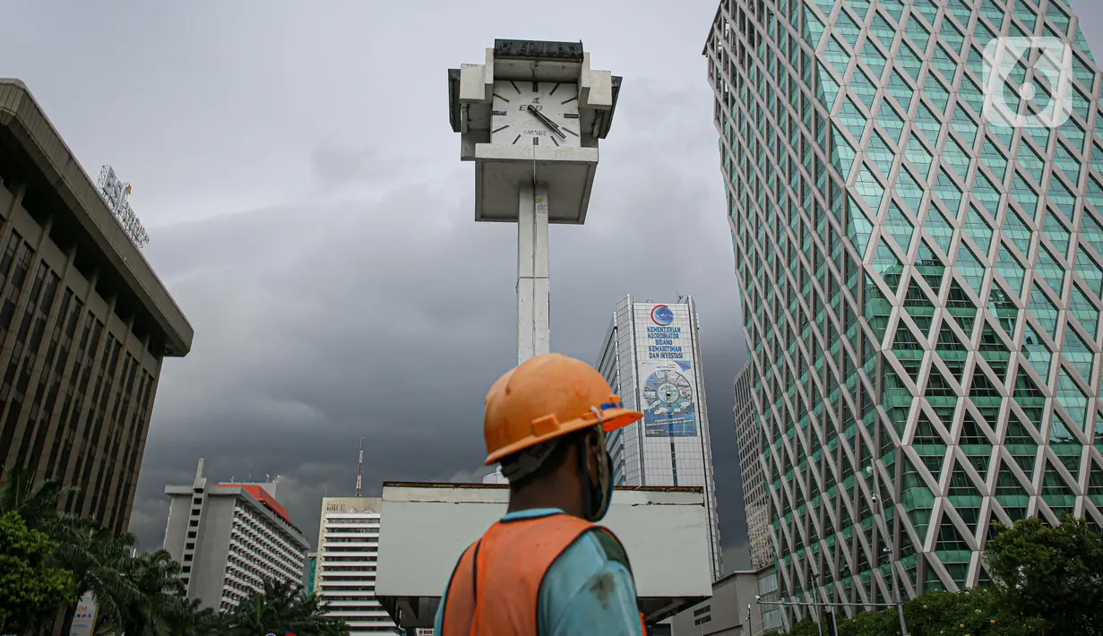Pekerja melintas di sekitar Menara Jam Thamrin, Jakarta, Sabtu (29/5/2021). Relokasi benda cagar budaya itu merupakan imbas pembangunan Stasiun MRT Thamrin. (Liputna6.com/Faizal Fanani)
