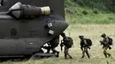 Tentara Italia berjalan menaiki helikopter saat mengambil bagian dalam latihan militer di sebuah kamp pelatihan di Tarquinia, dekat Roma, (21/5).  (AFP Photo/Tiziana Fabi)