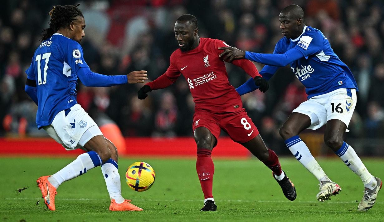 Gelandang Liverpool, Naby Keita (tengah) dikurung dua pemain Everton, Alex Iwobi (kiri) dan Abdoulaye Doucoure pada laga Liga Inggris 2022/2023 di Anfield Stadium, Liverpool (13/2/2023). Naby Keita yang berpaspor Guinea ini didatangkan Liverpool dari RB Leipzig pada awal musim 2018/2019 dengan nilai transfer senilai 60 juta euro atau kini setara Rp981 miliar. (AFP/Paul Ellis)