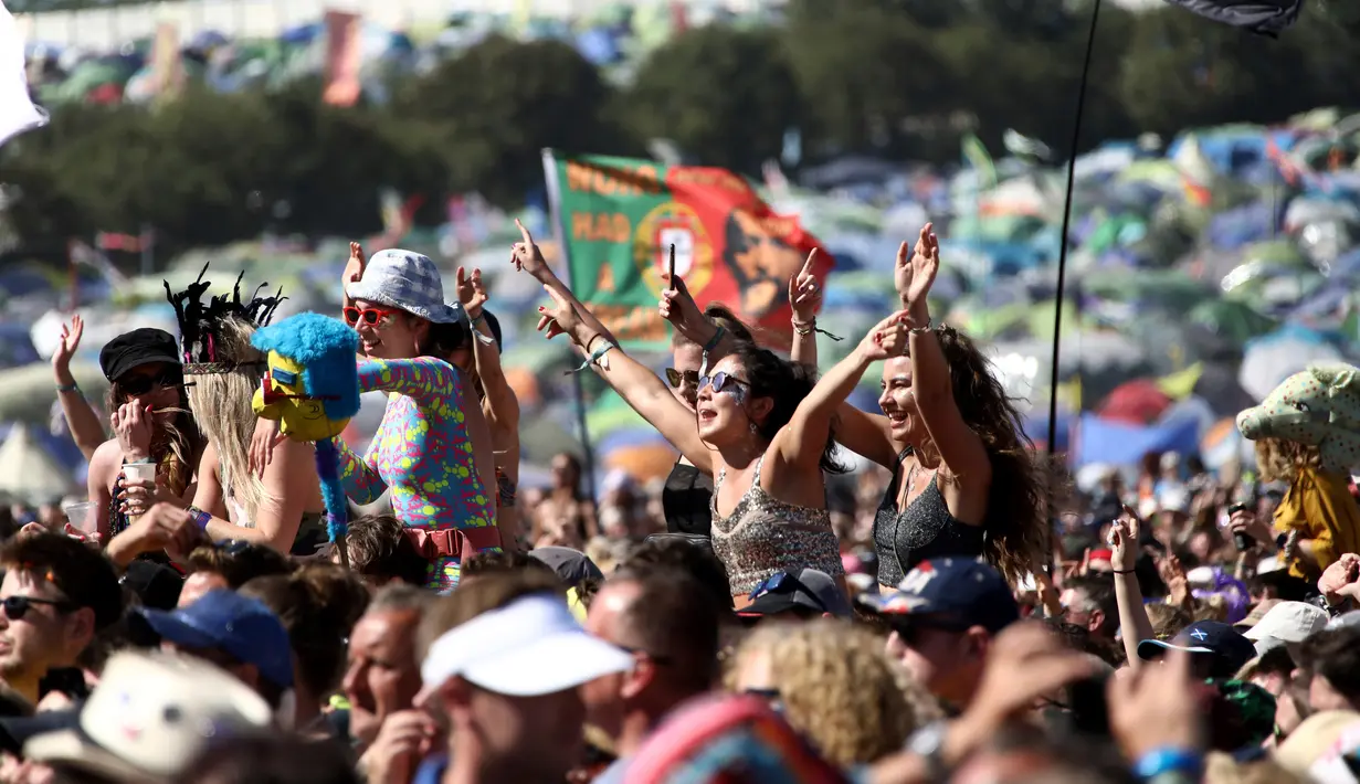 Sejumlah wanita berjoget menikmati musik selama hari keempat Festival Glastonbury di Worthy Farm, Somerset, Inggris (30/6/2019). Festival Glastonbury merupakan festival musik paling populer di dunia yang berlangsung lima hari. (AP Photo/Grant Pollard)