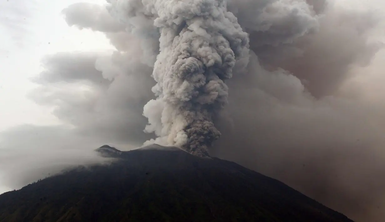 Kondisi Gunung Agung yang mengeluarkan asap tebal di Karangasem, Bali (28/11). Pihak berwenang memberi peringatan kepada warga untuk mengungsi akibat stasus Gunung Agung yang dari siaga ke awas. (AP Photo/Firdia Lisnawati)