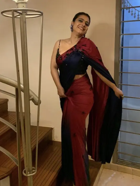 Kajol juga mengenakam kain sari modern warna merah dan hitam berdetail manik-manik. Dengan makeup boldnya. @kajol