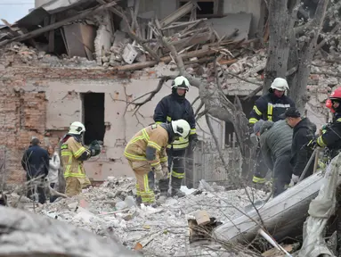 Tim penyelamat mencari korban di reruntuhan rumah yang hancur akibat serangan roket Rusia di pinggiran Lviv, Ukraina, Minggu 5 Oktober 2025. (AP Photo/Mykola Tys)