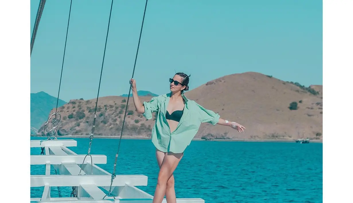 Mengarungi luasnya lautan tenang untuk menikmati panorama alam di sekitar Taman Nasional Komodo, sayang untuk tidak mengabadikannya dalam deretan foto. Bagi yang tak suka neko-neko, kemeja oversized bisa menjadi outerwear kece untuk dipadankan dengan swimwear kita, nih. (Foto: Instagram @ramadhaniabakrie)
