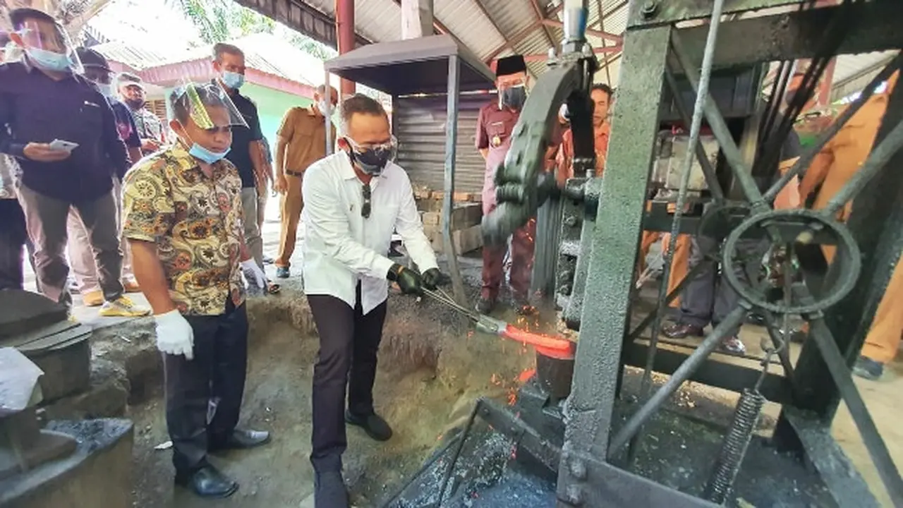 CEO PTPN V Jatmiko Santosa bersama Bupati Kampar Catur Sugeng mencoba menempa besi di Rumbio Jaya Steel.
