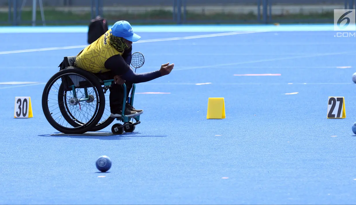 Atlet Para Games Indonesia cabang olahraga Lawn Bowls melakukan lemparan saat latihan di Lapangan Hoki Kompleks GBK, Jakarta, Selasa (18/9). Latihan ini adaptasi lapangan sekaligus persiapan jelang Asian Para Games 2018. (Liputan6.com/Helmi Fithriansyah)