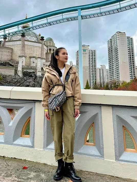 Mengikat rambut panjangnya, Sandra Dewi memilih mengenakan jaket warna beige yang dipadukan celana hijaunya.  [@sandradewi88]