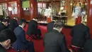 Orang-orang yang mengenakan masker wajah melakukan tradisi doa untuk Tahun Baru pada hari kerja pertama tahun ini di Kuil Kanda Myojin, di Tokyo, Jepang, Senin (4/1/2021).  Orang-orang berdoa untuk mencari keberuntungan dan bisnis yang Makmur. (AP Photo/Koji Sasahara)