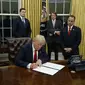 Presiden Donald Trump menandatangani perintah eksekutif pertamanya soal Obamacare (Associated Press)