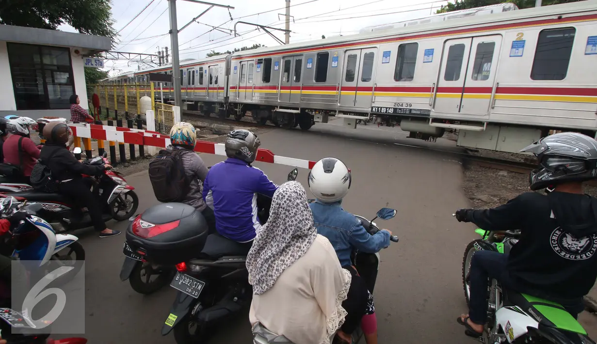 Pengendara berhenti di perlintasan kereta api Bintaro, Jakarta, Senin (16/1). Menurut pihak Dinas Bina Marga DKI Jakarta, rencananya jalan layang itu akan memiliki panjang 430 meter dengan lebar 9 meter. (Liputan6.com/Gempur M. Surya)