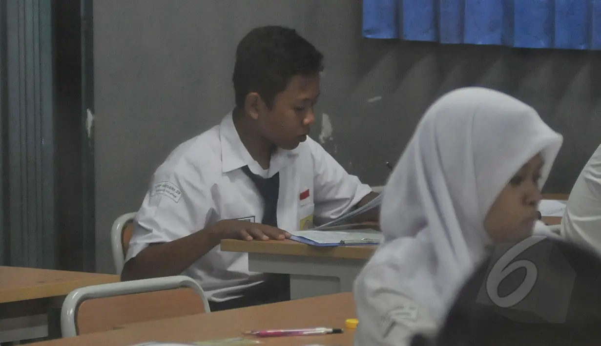 Seorang pelajar tampak tengah mengerjakan soal Ujian Nasional (UN) di SMPN 29 Jakarta, Senin (5/4/2015). UN tingkat SMP tersebut diikuti 149.172 peserta. (Liputan6.com/Johan Tallo)