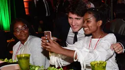 Seorang siswi SMA mengajak Perdana Menteri (PM) Kanada, Justin berswafoto ketika menghadiri acara Fortune Most Powerful Women Summit 2017 di Washington, Selasa (10/10). (AP Photo/Sait Serkan Gurbuz)