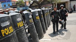 Puluhan anggota Brimob Polda Jatim membuat barikade penutup jalan Embong Malang, Surabaya, Jawa Timur, Sabtu (18/4/2015). Jalan Embong Malang, Surabaya ditutup total selama aksi unjuk rasa para supporter Persebaya 1927. (Liputan6.com/Helmi Fithriansyah)