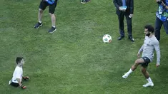 Gelandang Liverpool, Mohamed Salah saat bermain bola dengan seorang anak tanpa kaki saat sesi pelatihan jelang bertanding melawan Chelsea pada Piala Super Eropa 2019 di Stadion Taman Besiktas, di Istanbul (13/8/2019). (AP Photo/Lefteris Pitarakis)