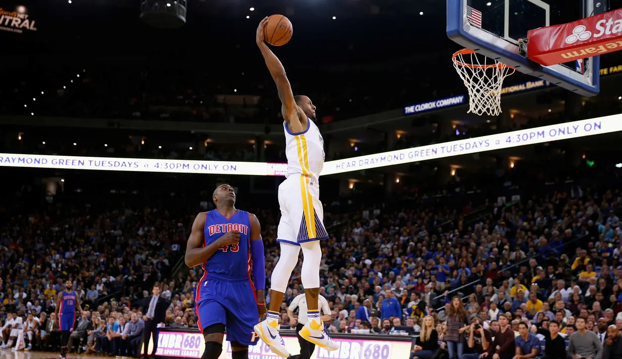 Pebasket Golden State Warriors Andre Iguodala melakukan Dunk saat dibayangi pebasket Detroit Pistons Anthony Tolliver di ORACLE Arena, California, Senin (9/11/2015). Warriors menang 109-95. (Getty Images/AFP/Ezra Shaw)