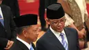 Menteri Luar Negeri Indonesia, Sugiono (kanan) berbicara dengan Menteri Dalam Negeri Tito Karnavian sebelum dimulainya upacara pengambilan sumpah para menteri baru di istana kepresidenan di Jakarta, Senin 21 Oktober 2024. (AP Photo/Achmad Ibrahim)