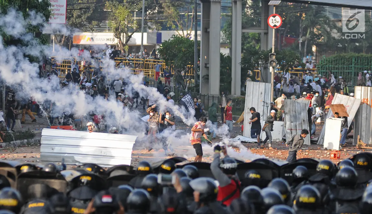 Petugas kepolisian menembakan gas air mata ke arah massa aksi saat terjadi bentrokan di kawasan Tanah Abang, Jakarta, Rabu (22/5/2019). Lantaran menolak bubar, aparat berkali-kali menembakan gas air mata ke arah massa. (Liputan6.com/Herman Zakharia)