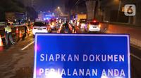 Petugas gabungan memeriksa dokumen pengendara yang melintas dari arah Jakarta di Pintu Tol keluar Cikarang Barat, kabupaten Bekasi, Jawa Barat, Kamis (6/5/2021) dini hari. Pemeriksaan tersebut terkait larangan mudik lebaran 2021 yang dimulai tanggal 6 hingga 17 Mei. (Liputan6.com/Herman Zakharia)