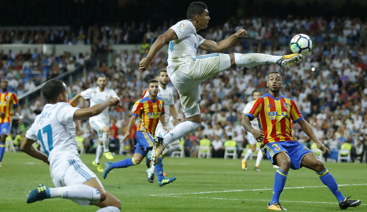 Aksi pemain Real Madrid, Casemiro melakukan tembakan dengan melompat saat melawan Valencia pada lanjutan La Liga Spanyol di Santiago Bernabeu stadium, Madrid, (27/8/2017). Real ditahan Imbang 2-2. (AP/Francisco Seco)