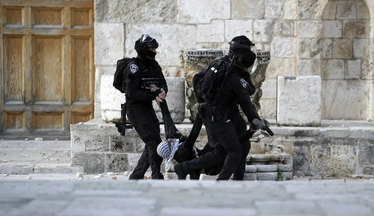 <p>Polisi Israel membawa seorang pengunjuk rasa Palestina saat bentrok di Kompleks Masjid Al Aqsa, Yerusalem, Jumat (22/4/2022). Polisi Israel dan pemuda Palestina kembali bentrok di Kompleks Masjid Al Aqsa. (AP Photo/Mahmoud Illean)</p>