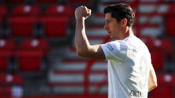 Striker Bayern Munchen, Robert Lewandowski, melakukan selebrasi usai membobol gawang Union Berlin pada laga Bundesliga  di Alte Foersterei, Minggu (17/5/2020). Bayern Munchen menang 2-0 atas Union Berlin. (AP/Hannibal Hanschke)