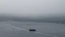 Kapal feri melintas saat badai awan sebelum hujan deras di pelabuhan Victoria Harbour Hong Kong, (6/3). (AFP Photo/Anthony Wallace)