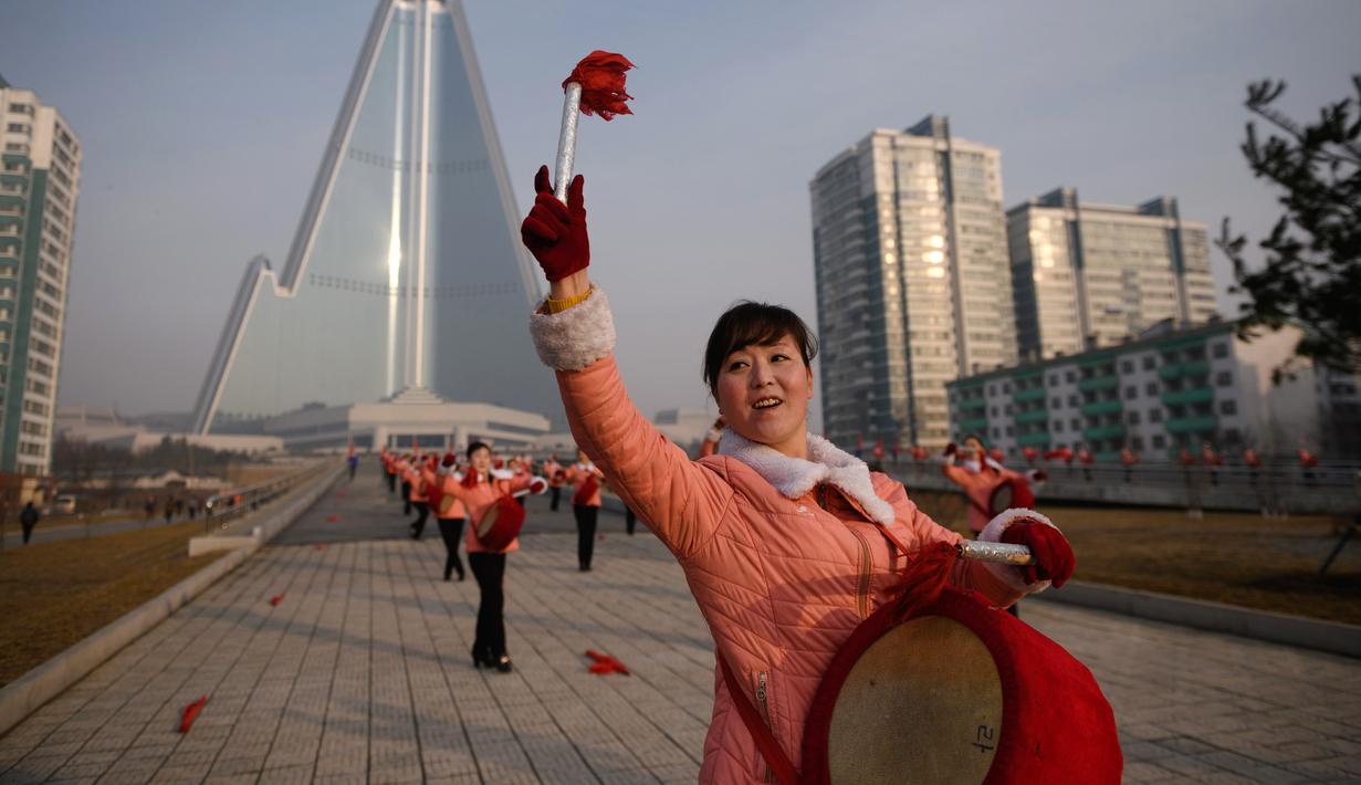 Kelompok Serikat Wanita Sosialis memukul genderang saat melakukan propaganda di depan Hotel Ryugyong, Pyongyang, Korea Utara, Sabtu (9/3).Dalam aksinya, mereka juga memuji-muji Pemimpin Korea Utara Kim Jong-un. (Ed Jones/AFP)