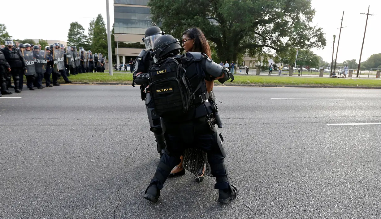 Polisi Anti Huru Hara AS menangkap seorang wanita yang melakukan unjuk rasa di dekat markas Kepolisian Rouge Baton di Baton Rouge, Louisiana, AS (9/7). Unjuk rasa tersebut sebagai aksi protes terkait kebrutalan polisi di AS. (REUTERS / Jonathan Bachman)