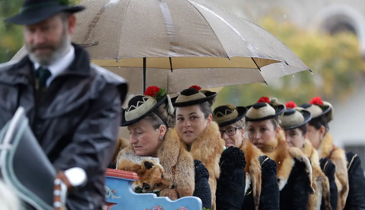 Sejumlah wanita mengenakan kostum tradisional dari kawasan setempat duduk di kereta kuda selama acara ziarah tradisional Leonhard di Warngau, Jerman (22/10). Ziarah ini dilakukan setiap tahun. (AP/Matthias Schrader)