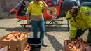 Petugas margasatwa NSW memuat wortel dan ubi jalar untuk walabi yang menjadi korban kebakaran hutan di sepanjang Pantai Selatan New South Wales pada 10 Januari 2020. Kebakaran hutan dan semak di Australia sudah berlangsung sejak September 2019. (STR/NSW NATIONAL PARKS AND WILDLIFE SERVICES/AFP)
