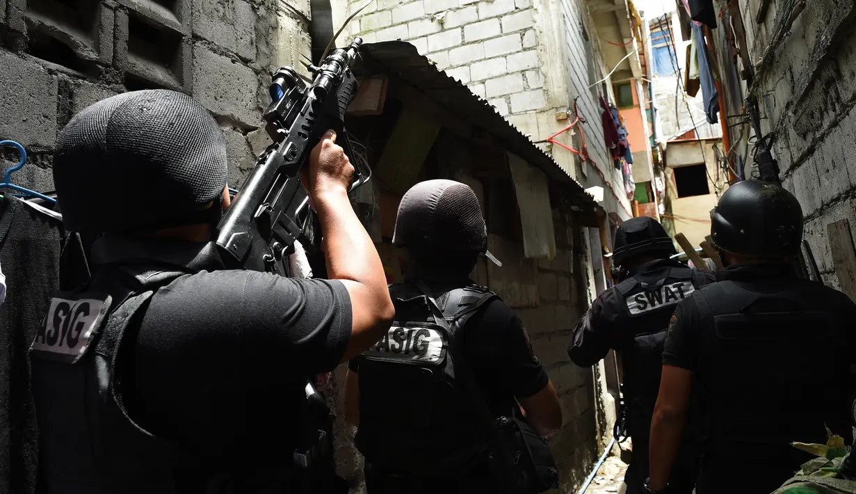 Dalam gambar yang diambil pada 5 September 2016, anggota tim SWAT Kepolisian Filipina mengambil posisi sambil membawa senjata mereka saat mengepung sebuah rumah dalam operasi anti-narkoba di kawasan pemukiman di pinggiran Kota Manila. (TED Aljibe/AFP)